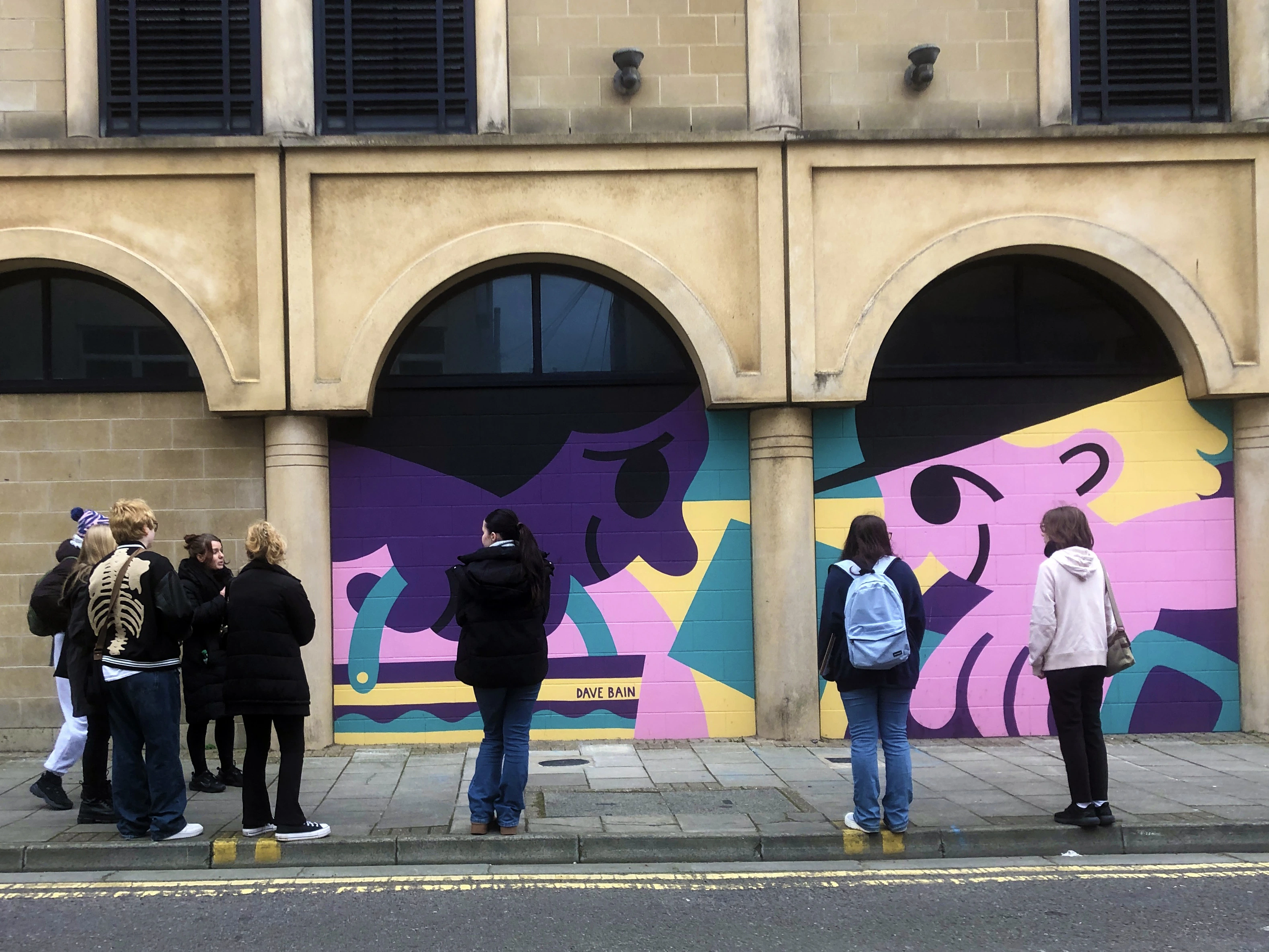 Young artists in Weston-super-Mare appreciating wall art.